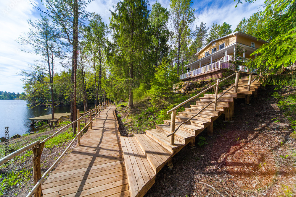 Fototapeta premium Wooden paths near the lake in the spring forest of Karelia
