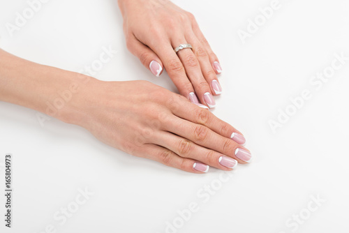 close-up view of beautiful female hands with french manicure isolated on white