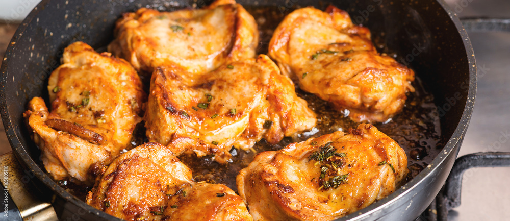 Fried chicken thighs in pan closeup. Fried chicken thighs in pan closeup.