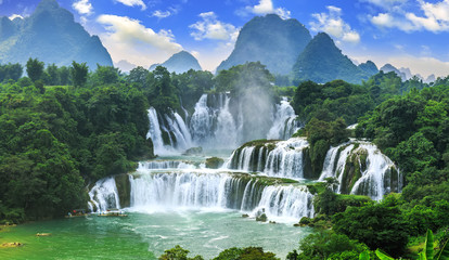 Tuinposter Watervallen Ruisende waterval tussen rotsachtige rotswanden  © zhouyilu