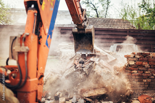 Details of backhoe excavator scoop demolishing ruins, destroying and loading debris