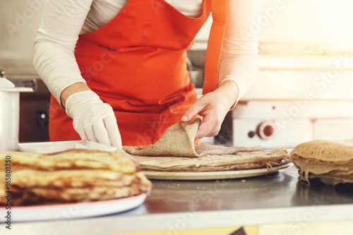 Bild auf Leinwand femme préparant des crêpes dans camion, street food
