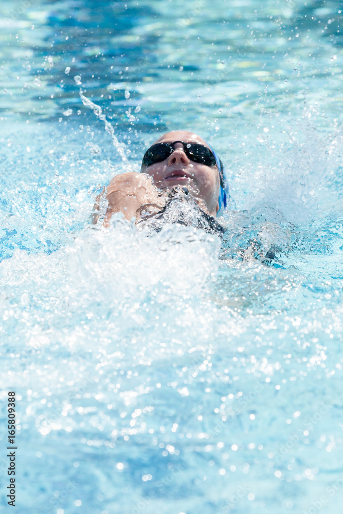 Young Female Swimming Backstroke