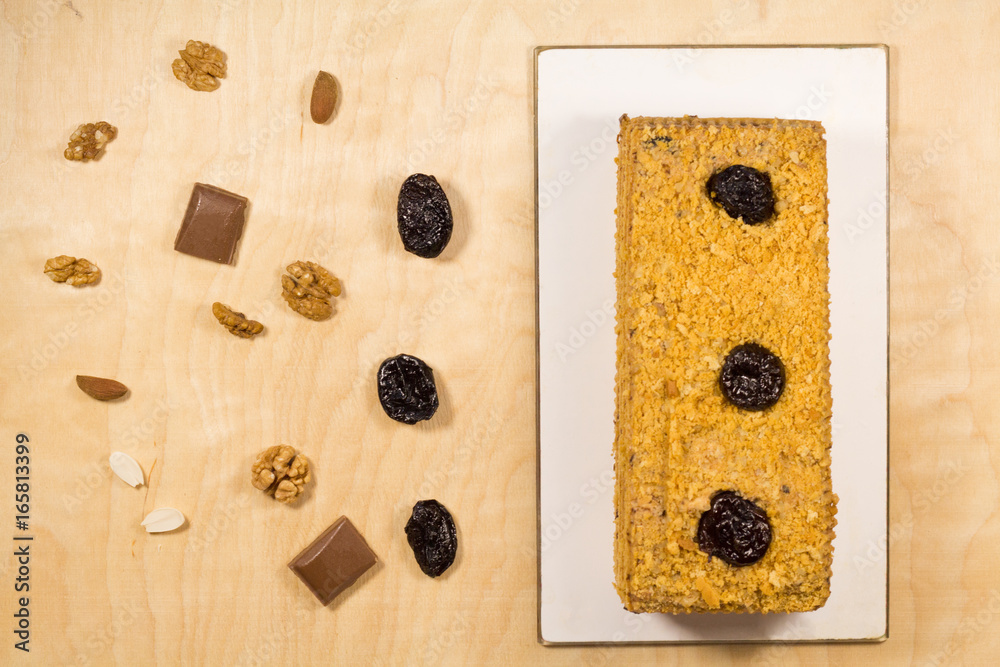 Delicious prune cake divided with nuts on wooden background Delicious prune cake divided with nuts on wooden background