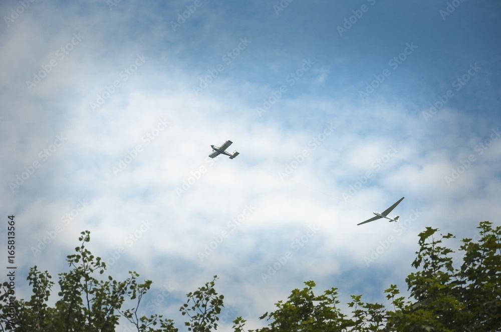 a glider hauled by plane against blue sky a glider hauled by plane against blue sky