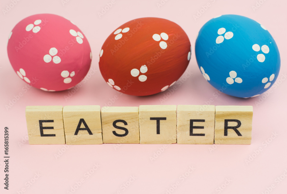 Text wooden blocks spelling the word easter on pink background Text wooden blocks spelling the word easter on pink background