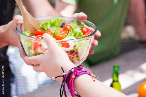 Friends eating outdoor sharing salad