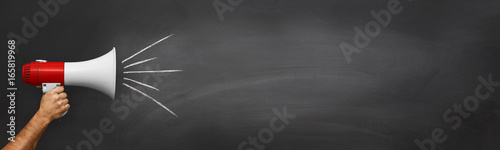 Fotografie, Obraz Hand with a megaphone in front of an empty blackboard