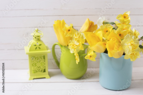 Spring daffodils or narcissus flowers and decorative green lanterns