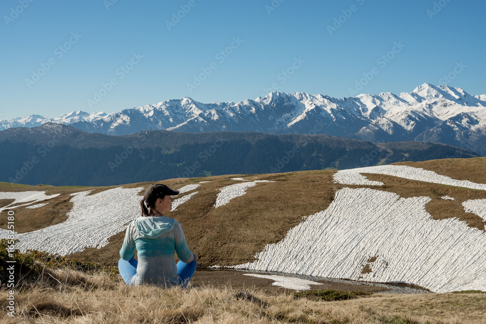 Fototapeta premium Woman traveler is relaxing admiring mountain range