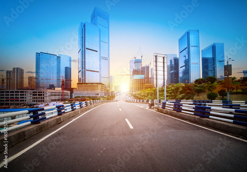 road and buildings at city with sunset