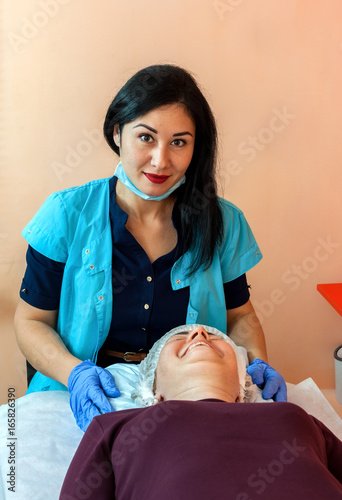 The cosmetologist with the patient in beauty salon photo