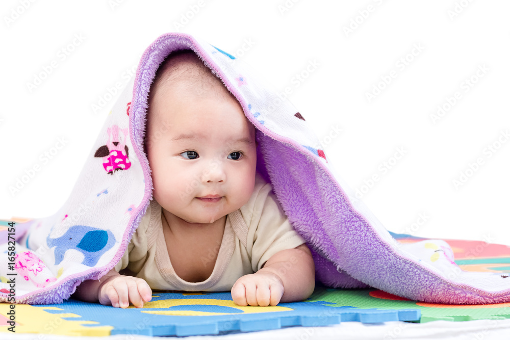 Portrait of a little adorable infant baby girl with blanket lying on the tummy on colorful eva foam indoors Portrait of a little adorable infant baby girl with blanket lying on the tummy on colorful eva foam indoors