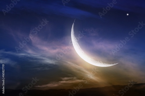 Obraz na płótnie Red sunset and moon . Light in dark sky . beautiful cloud . Ramadan background . Prayer time . Dramatic nature background . Red sunset and moon . w salonie