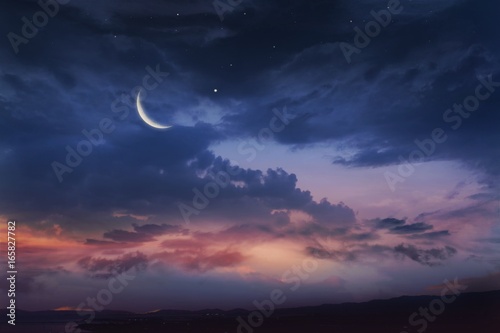 Romantic sunset and mystical moon .. Ramadan background . Prayer time . Dramatic nature background . Red sunset and moon .