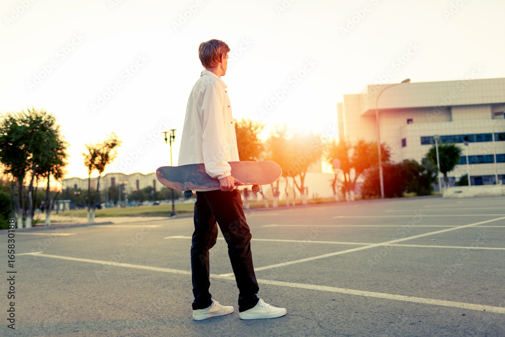 Φωτογραφία teenager skateboarding in a park on a day off in sunny weather