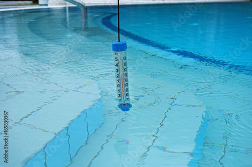 A thermometer immersed in water in the pool
