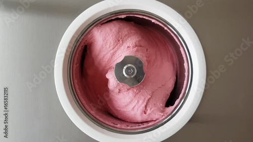 Homemade raspberry ice cream churning in a small professional  ice cream machine. 