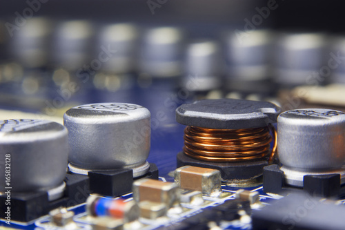 Close up macro of an Electromagnetic coil and electronic component mount in electronics motherboard with selective focus. Electronics part concept.