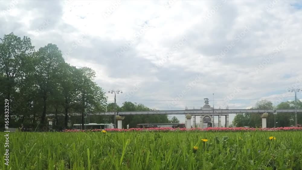 Flowerbed and monorail in front of arch at summer timelapse Flowerbed and monorail in front of arch at summer timelapse