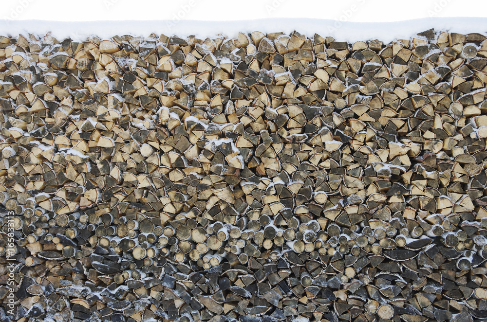 Birch firewood stacked in a woodpile covered with snow Birch firewood stacked in a woodpile covered with snow