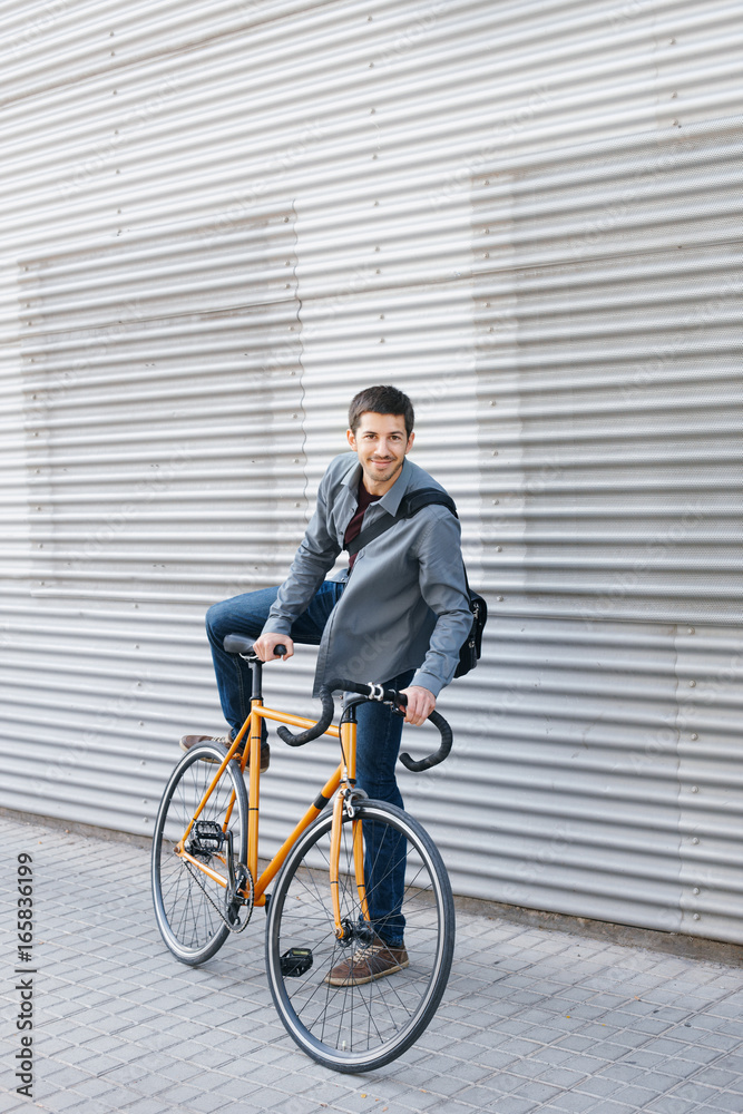 Young business man gets on his city bike Young business man gets on his city bike