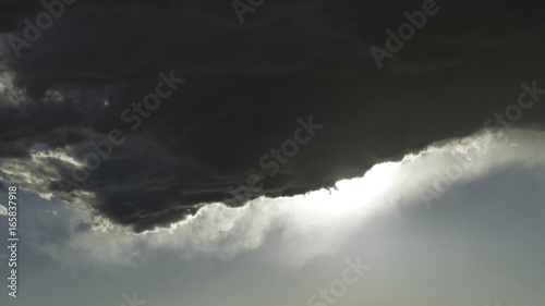 edge of a cumulus cloud with wispy edge backlit by the afternoon sun