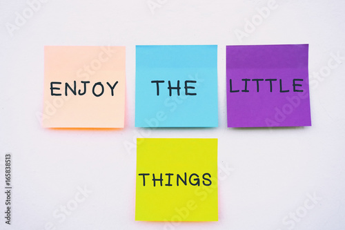 Enjoy the little things - Inspirational and motivation quotes on colorful sticky paper on a wall, pastel colors.