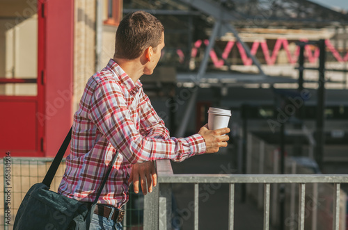 Man Standing on the Street and Holding Coffee photo