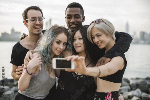 Multi ethnic group of friends taking a selfie outdoors photo
