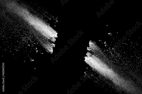 Freeze motion of white dust explosion on black background. Stopping the movement of white powder on dark background. Explosive powder white on black background.