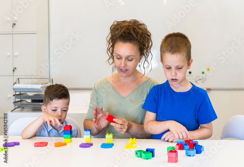 teacher woman learn two preschooler boy to count