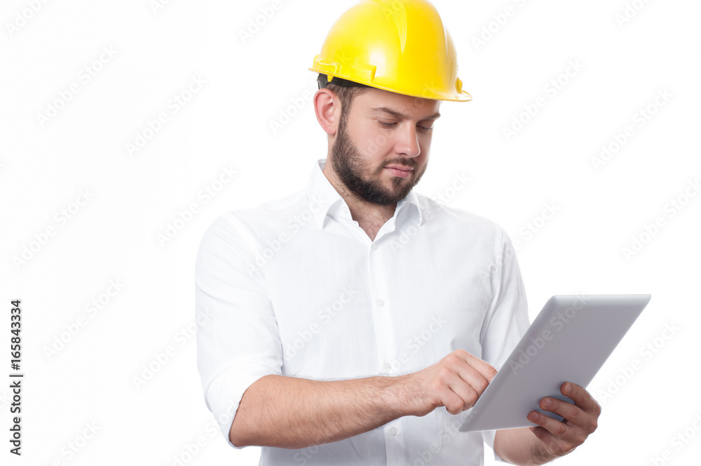 Contractor in yellow builder helmet working on a project with tablet.