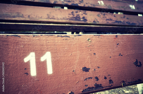 Number eleven painted on an old wooden seat, conceptual picture with copy space on the right. photo