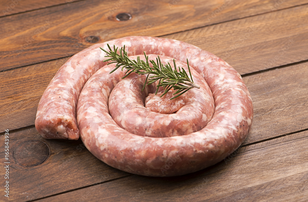 From above raw sausage with rosemary branch on wooden table. From above raw sausage with rosemary branch on wooden table.