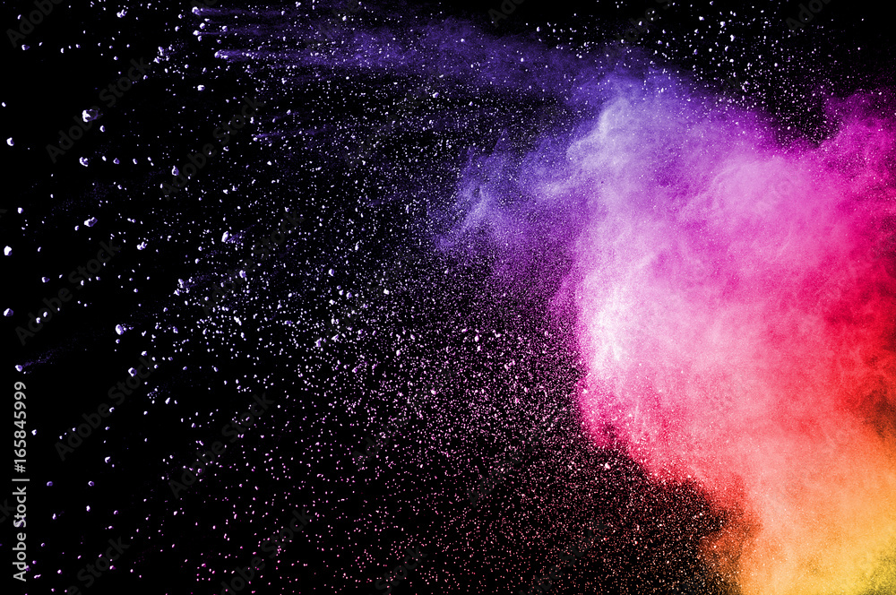 Abstract art colored powder on black background. Frozen abstract movement of dust explosion multiple colors on black background. Stop the movement of multicolored powder on dark background.