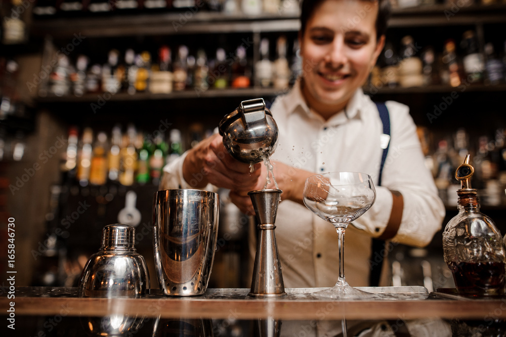 smiling bartender making cocktail at the bar counter