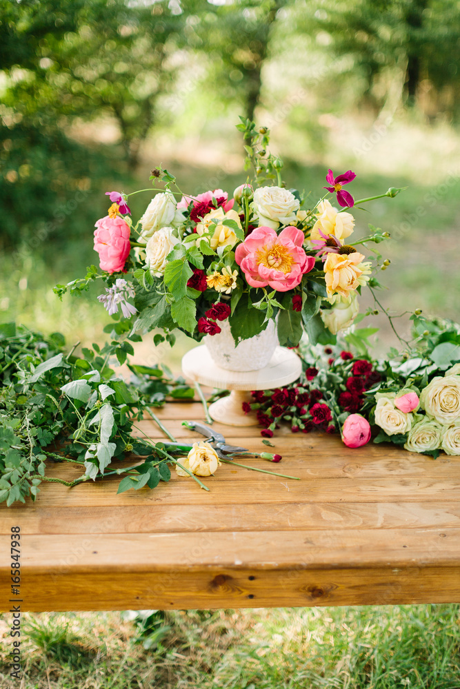 bouquet, holiday flower, gift and floral arrangement concept - wonderful bouquet in white vase on wooden table at green garden, white and yellow roses, pink peonies, red carnations, vertical