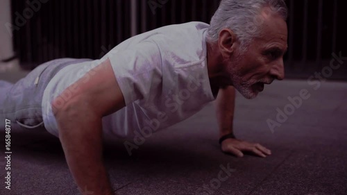 Strong senior man doing press up exercises