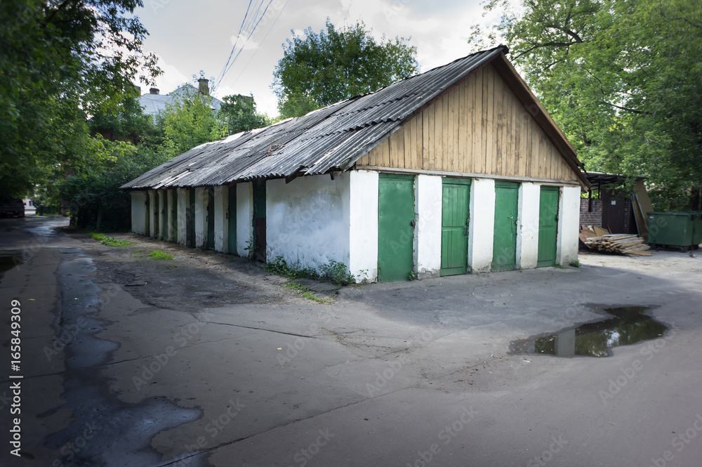 Old wooden bar with grey roof and many green doors Old wooden bar with grey roof and many green doors