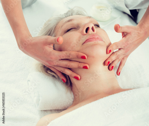 Mature woman having face massage