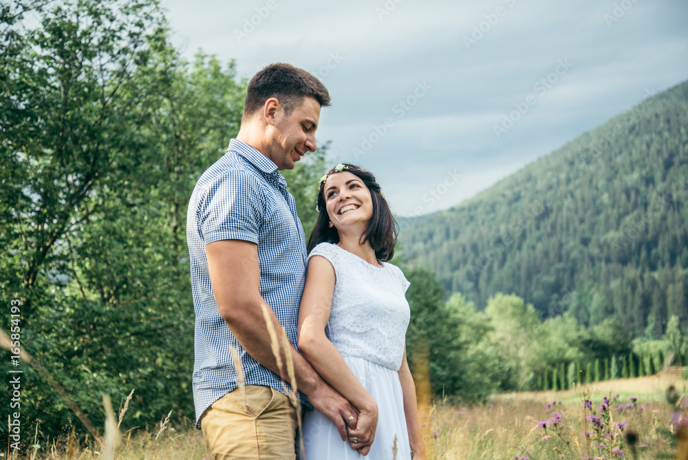 couple in love walking in feild with beautiful view on moutains couple in love walking in feild with beautiful view on moutains