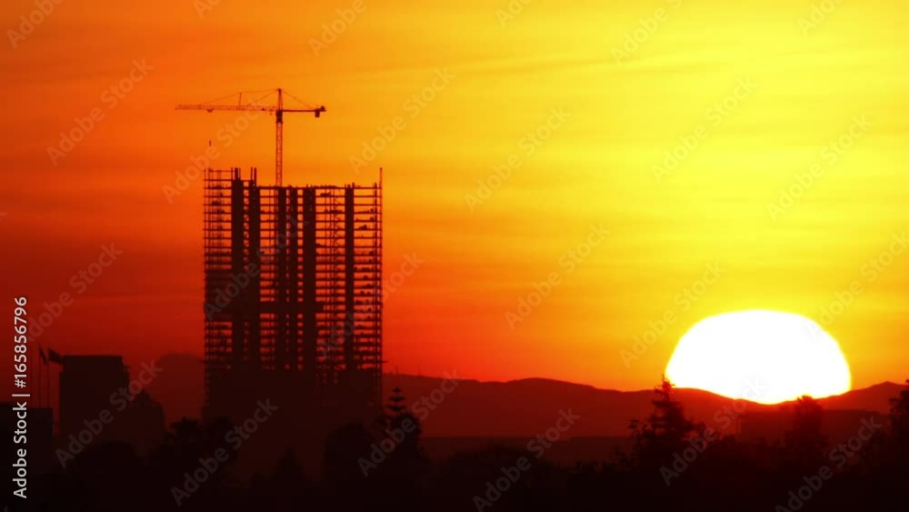 Time Lapse of the Sun rising behind a high-rise construction in Los Angeles.