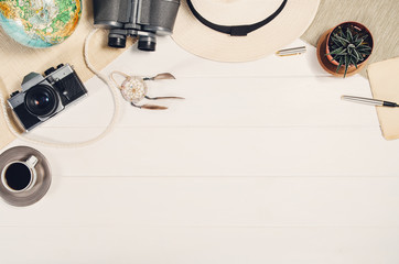 Accessories for travel top view on white wooden background with copy space. Adventure and wanderlust concept image with travel accessories. Preparing for an exotic trip, journey and sightseeing.