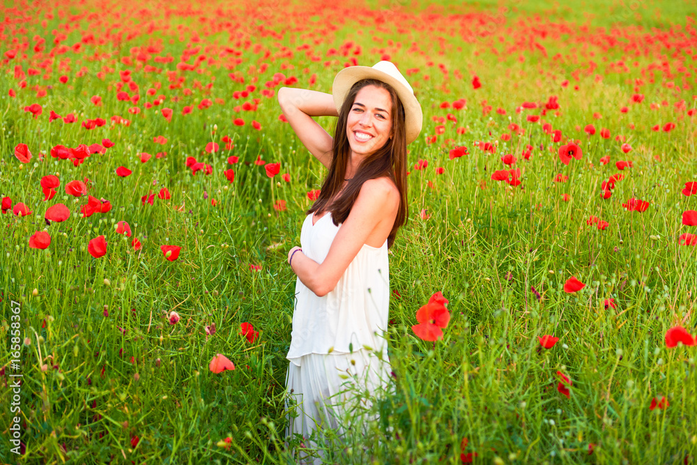 A happy woman in the field of red poppies A happy woman in the field of red poppies