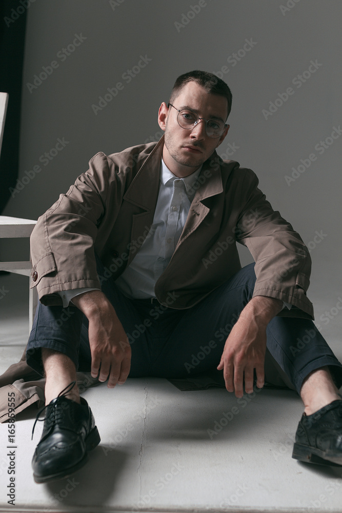 A lonely handsome guy in a raincoat and glasses with different moods A lonely handsome guy in a raincoat and glasses with different moods