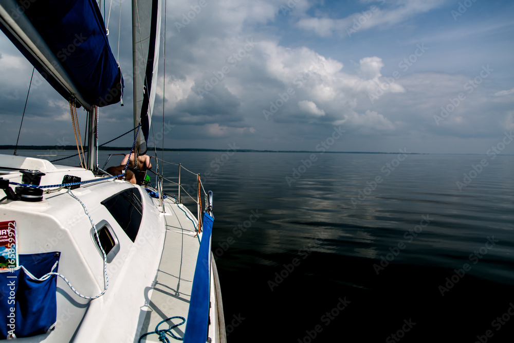 Sailing on white sail boat in Polish lake district Sailing on white sail boat in Polish lake district