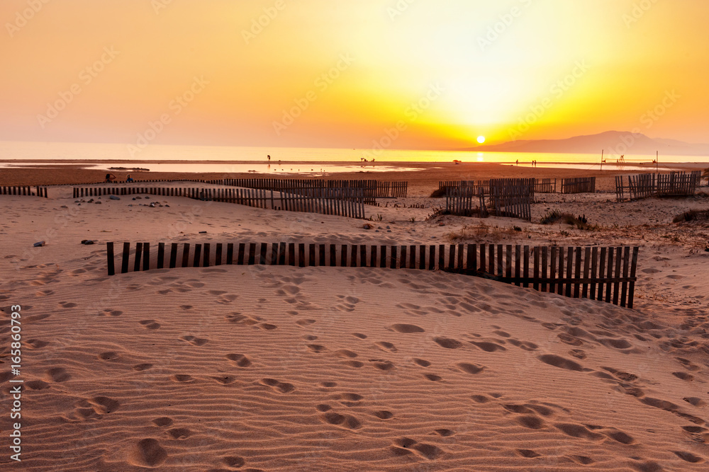 Beach with wooden fence and sand footprints, Tarifa, Spain