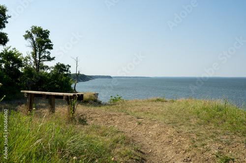 Bench on the shore of the lake on a summer day © photocinemapro