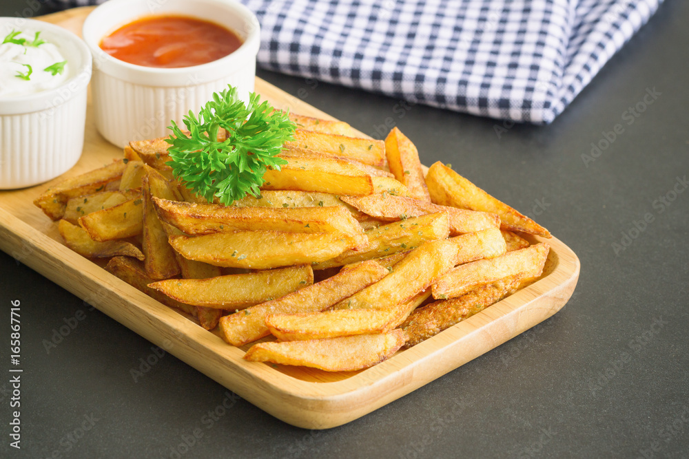 Homemade french fries serve with ketchup and sour cream or mayonnaise. Golden brown crispy french fries sprinkle with salt and oregano on plate for snack or appetizer. French fries on granite table. Homemade french fries serve with ketchup and sour cream or mayonnaise. Golden brown crispy french fries sprinkle with salt and oregano on plate for snack or appetizer. French fries on granite table.
